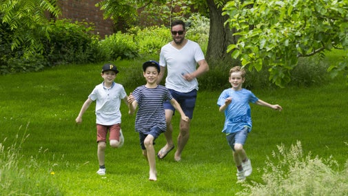 Father and his three sons playing chase in the garden at Chartwell.